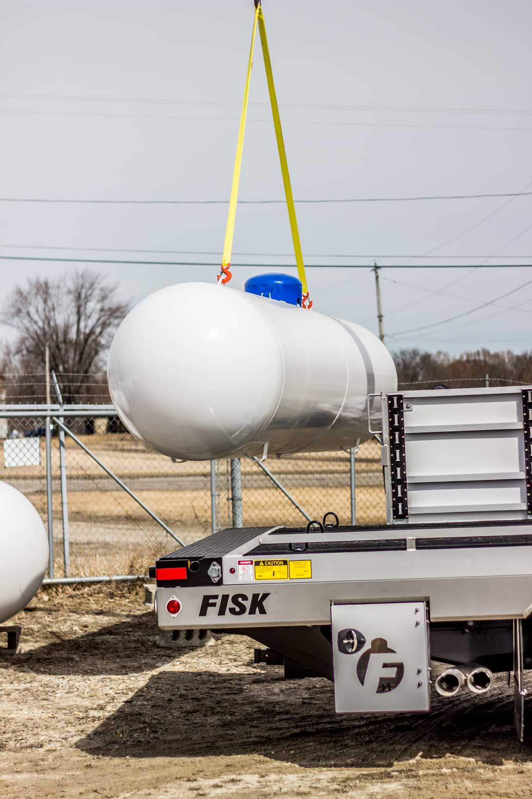 large white tank pulled by crane