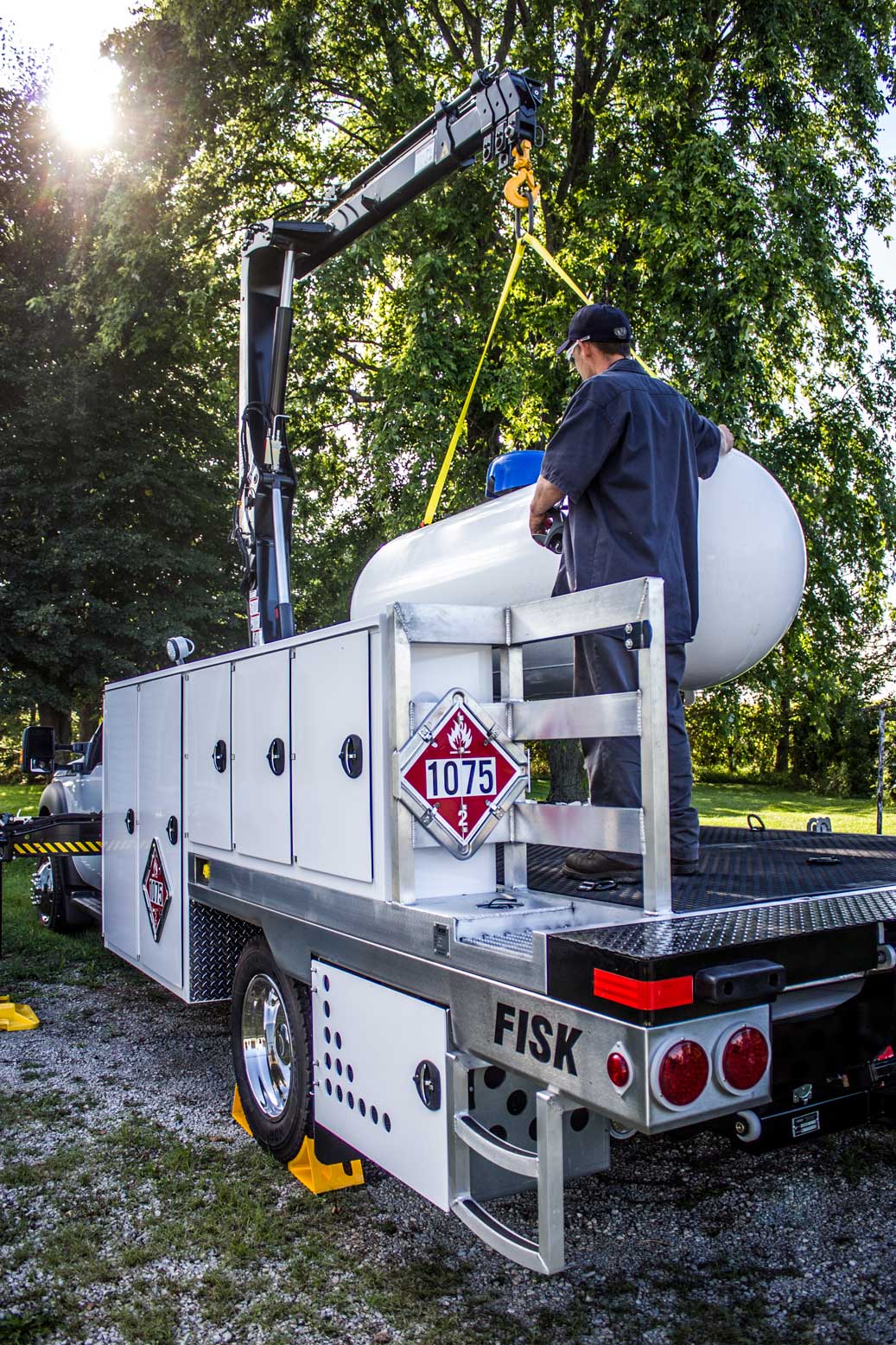 Serviceman placing a propane tank in the bed of a service truck
