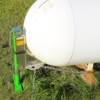 Propane tank jack lifting a propane tank in a yard