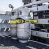 Load hug strap securing tanks on a truck