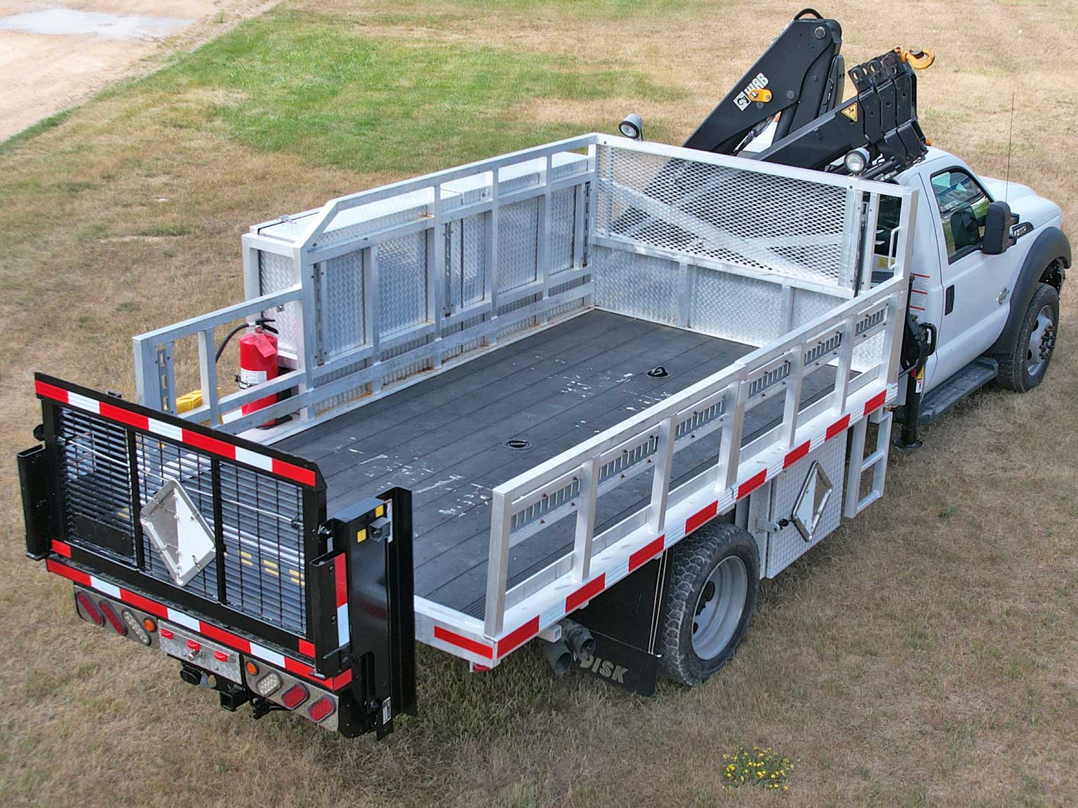 A silver and white Fisk truck with a crane on top of it