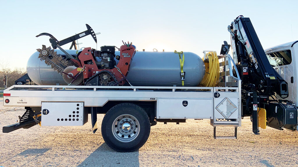 Image contains 1000 gal propane tank and trench digger on the back of a Fisk propane truck.